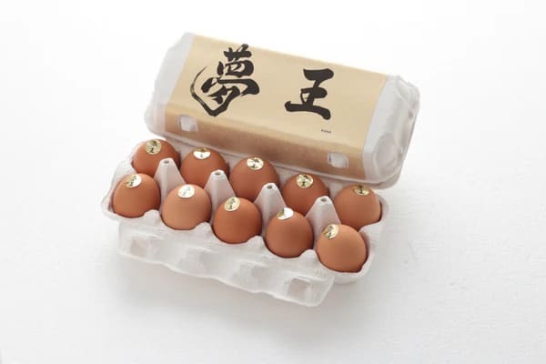 ブランド卵「夢王」のパッケージと、ケースに並べられた茶色い卵