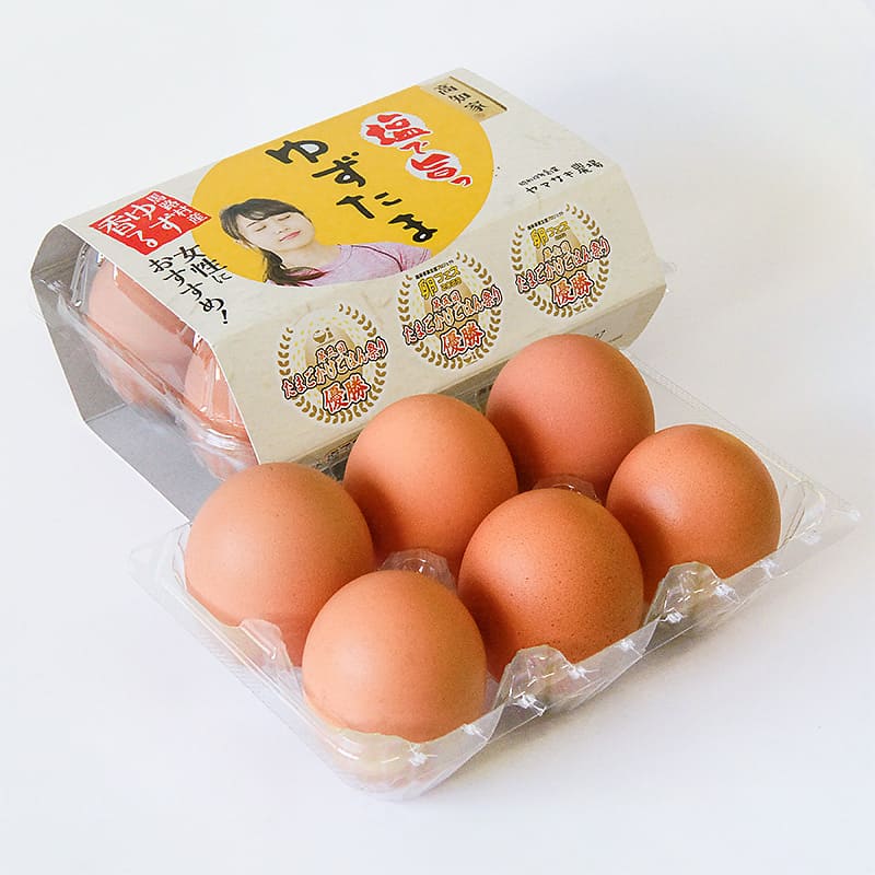 高知県産ブランド卵「ゆずたま」のパッケージと、ケースに並べられた茶色い卵